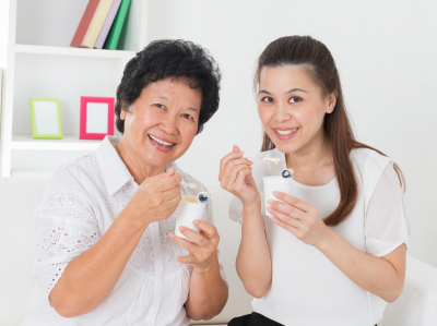 caregiver and senior woman eating healthy food