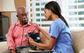 caregiver checking up an elderly man