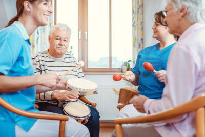 caregiver and group of seniors playing instruments