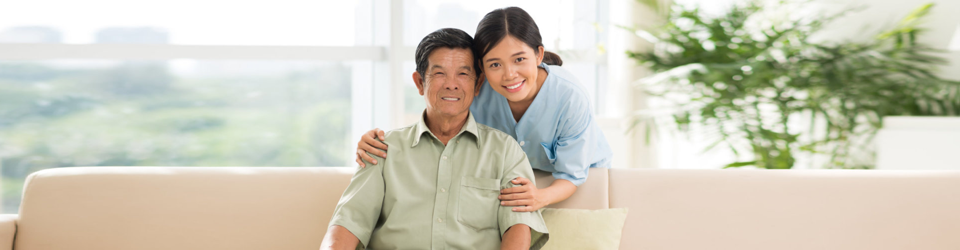 caregiver and an elderly man smiling at the camera